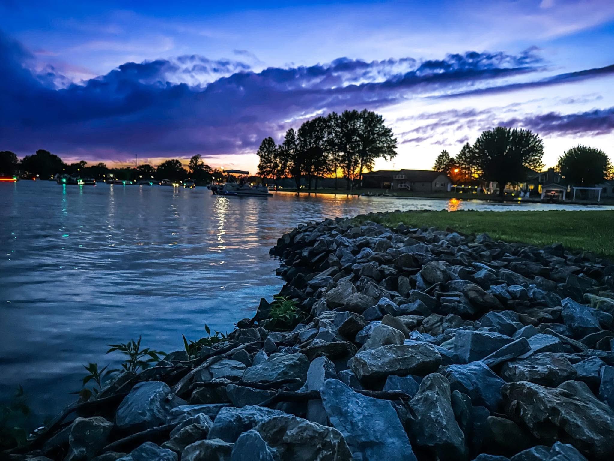 Sunset over Lake Santee, Indiana — boats on the water and cabins along the far shore